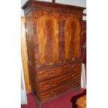 An early Victorian mahogany and flame mahogany linenpress, the twin proud panelled arched upper