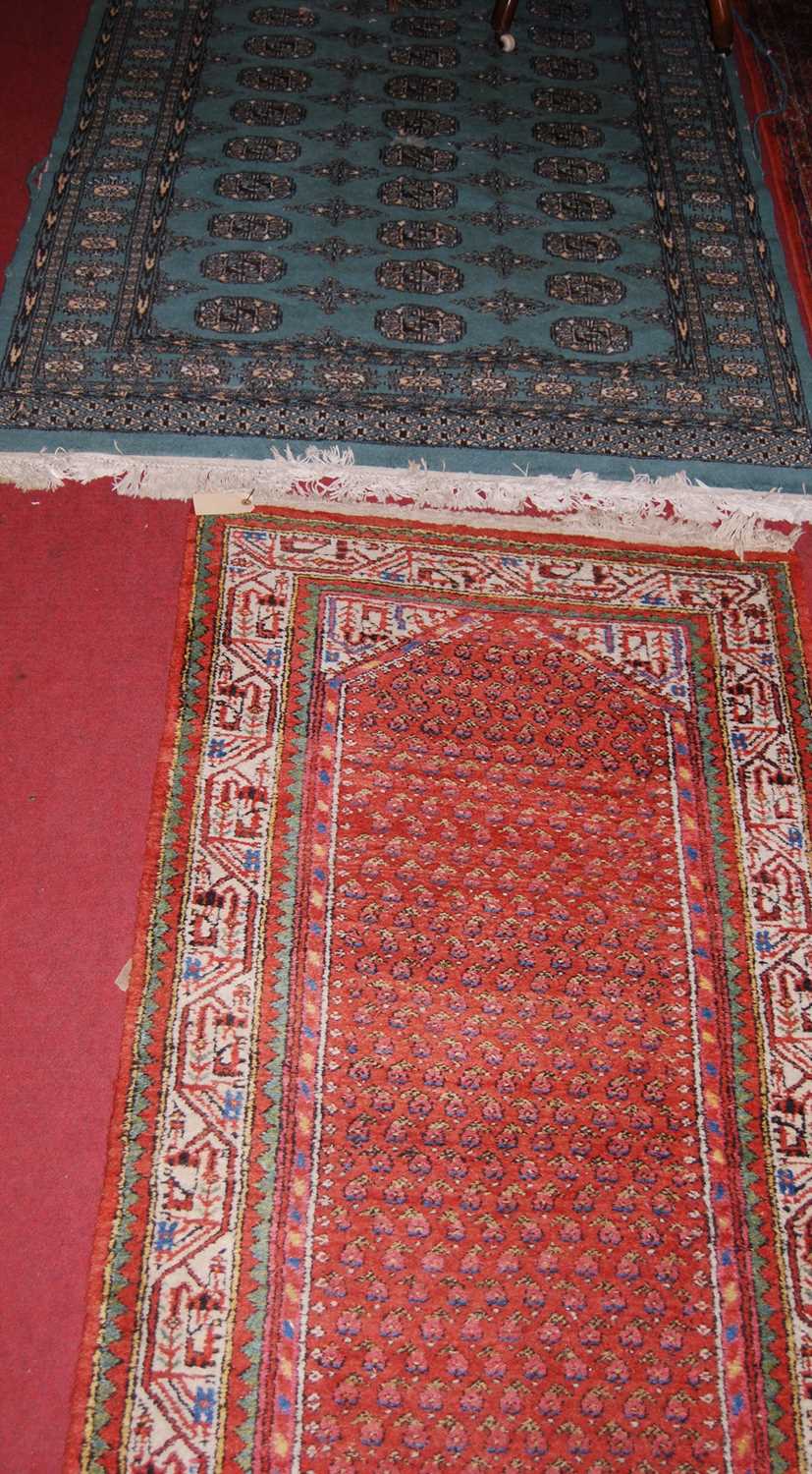 A Persian woollen green ground Bokhara rug (with wear), 187 x 126cm; together with a Persian woollen