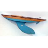 Bowman yacht hull without mast, with keel, varnished above waterline, turquoise below, with