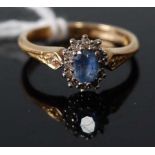 An 18ct yellow and white gold, sapphire and diamond oval cluster ring, the centre sapphire measuring