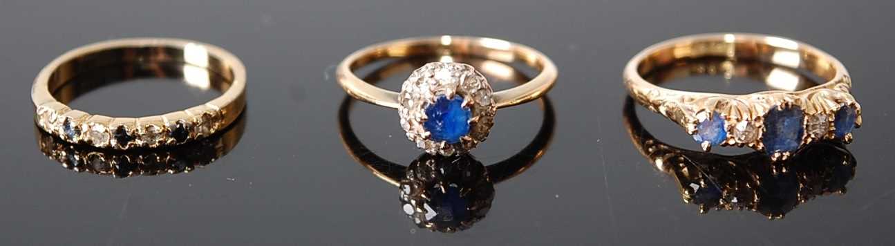 Three rings, comprising a yellow metal, sapphire and diamond five-stone half hoop eternity ring,