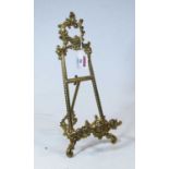 A 19th century miniature brass easel, decorated in the Rococo taste, with C scrolls and rocaille,