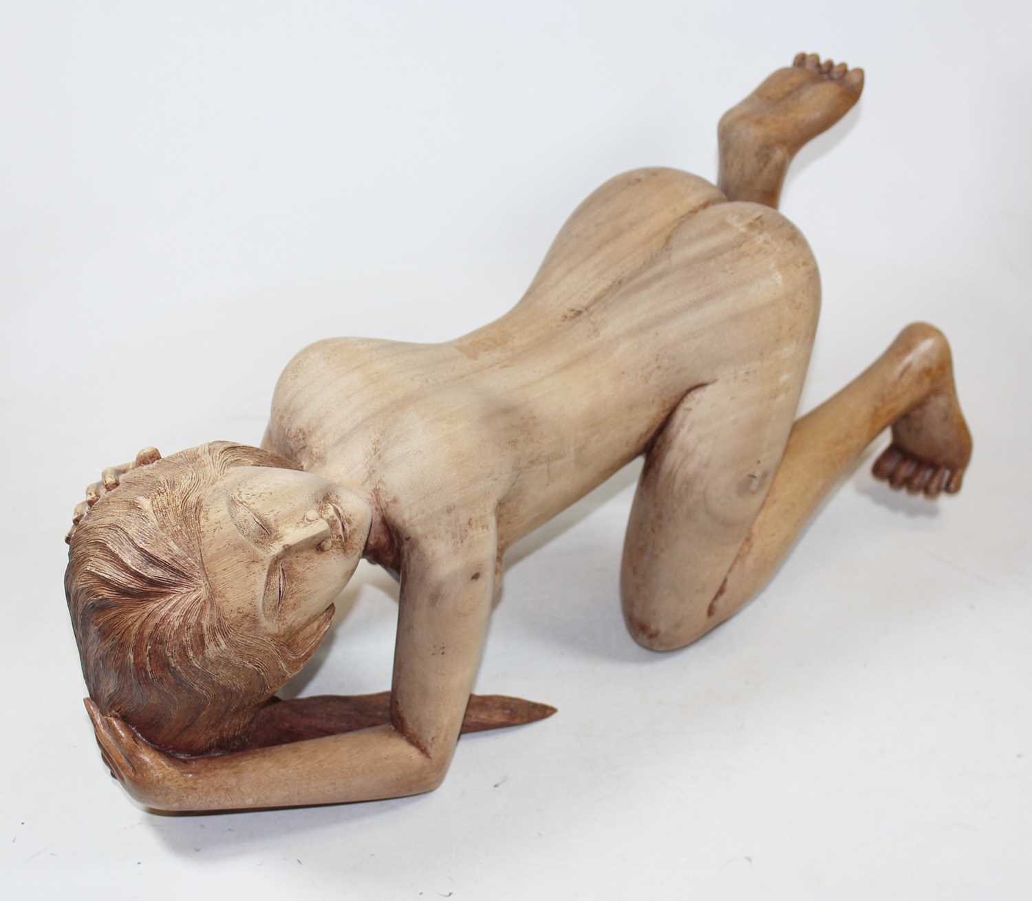 An Eastern carved hardwood figure of a nude woman, shown on all fours, h.22cm