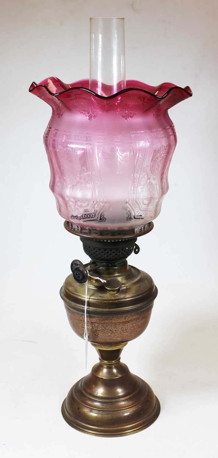 A Victorian brass oil lamp, with acid etched cranberry glass shade, h.51cmCondition report: Shade