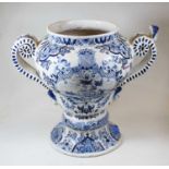 A late 18th century Dutch Delft urn, of baluster form flanked by twin scrolled handles, decorated