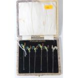 A set of six mid-20th century sterling silver cocktail sticks, each terminal enamel decorated in the
