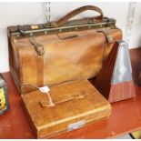 A tan leather Gladstone bag; together with a late 20th century metronome; and a tan leather clad