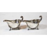 A pair of George V silver sauceboats, of plain undecorated form, each having a wavy rim and raised