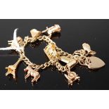 A 9ct gold gatelink bracelet, containing various 9ct charms and two gilt metal charms, gross