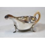 An early 20th century silver sauceboat, of plain undecorated form, having replacement bone handle,