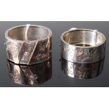 Two white metal oval hinged bangles, each with engraved gilded floral detail, w.24 and 32mm, inner