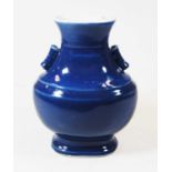 A Chinese export blue glazed vase of hu form, the flared rim above a waisted neck, flanked by twin