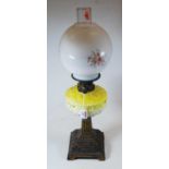 A late Victorian oil lamp, having an associated opalescent glass shade and yellow glass font, on a
