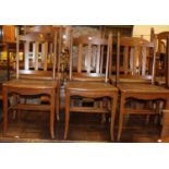 A set of eight early 20th century oak bar and slat back dining chairs, each having studded tan