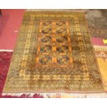 A Turkish woollen Teki-Bokhara rug, the rust coloured field decorated with three rows of