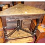 An antique joined oak corner occasional table, raised on turned and square cut supports, width 72cm,