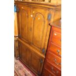 A contemporary moulded oak four door side cupboard, having recessed panelled doors with central