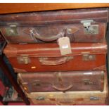 A vintage stitched leather suitcase, with metal fittings; and three other suitcases with leather