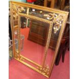 A large contemporary floral gilt decorated bevelled rectangular wall mirror, 121 x 89cm