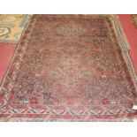 A Turkish woollen rug, the red ground decorated with linked medallions, stylised animals, flowers