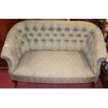 A Victorian green floral button back upholstered two seat parlour sofa, raised on squat cabriole