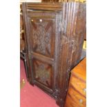 A provincial antique chip carved oak single door side cupboard, having exposed and shaped iron