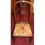 A set of four Edwardian mahogany splat back dining chairs having floral upholstered drop-in pad