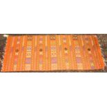 A Persian woollen Kilim rug, having an orange ground and banded decoration, 55 x 134cm