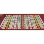 A Turkish woollen Kilim rug, woven in seven sections with banded and geometric decoration, 142 x