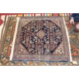 An Afghan woollen rug, the blue ground decorated with a central medallion, stylised flowers and