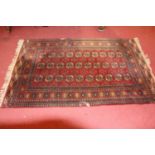 A Turkish woollen Bokhara rug, having a red ground (worn and with losses), 130 x 205cm; together