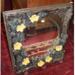 A heavily floral decorated gesso moulded rectangular wall mirror, the mirror plate housed as an oval