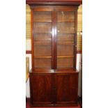 A Victorian mahogany bookcase cupboard, having twin glazed upper doors with adjustable shelved