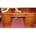 A mahogany and gilt tooled red leather inset twin pedestal writing desk, having an arrangement of