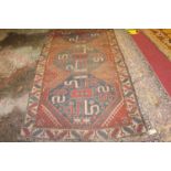 An Afghan woollen rug, the blue ground decorated with three linked medallions and geometric