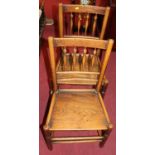 A pair of early 20th century provincial elm panelled seat spindle back dining chairs