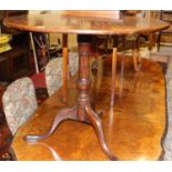A George III mahogany circular tilt-top pedestal tripod table, raised on hipped outswept supports,