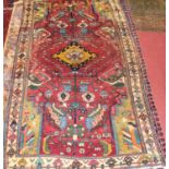 A Turkish woollen rug, the red ground decorated with flowers and foliage in geometric designs, all