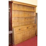 A Victorian pine freestanding kitchen dresser, having graduated three-tier platerack over base