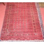 A Turkish woollen Bokhara rug, the red ground decorated with five rows of linked medallions within
