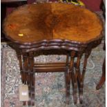 A walnut and figured walnut piecrust topped nest of three occasional tables, the largest width 56cm