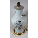 A French porcelain table lamp of baluster form on a cream ground, decorated with flowers