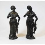 A pair of bronze figures, each modelled as a lady in standing pose with one arm slightly raised, h.