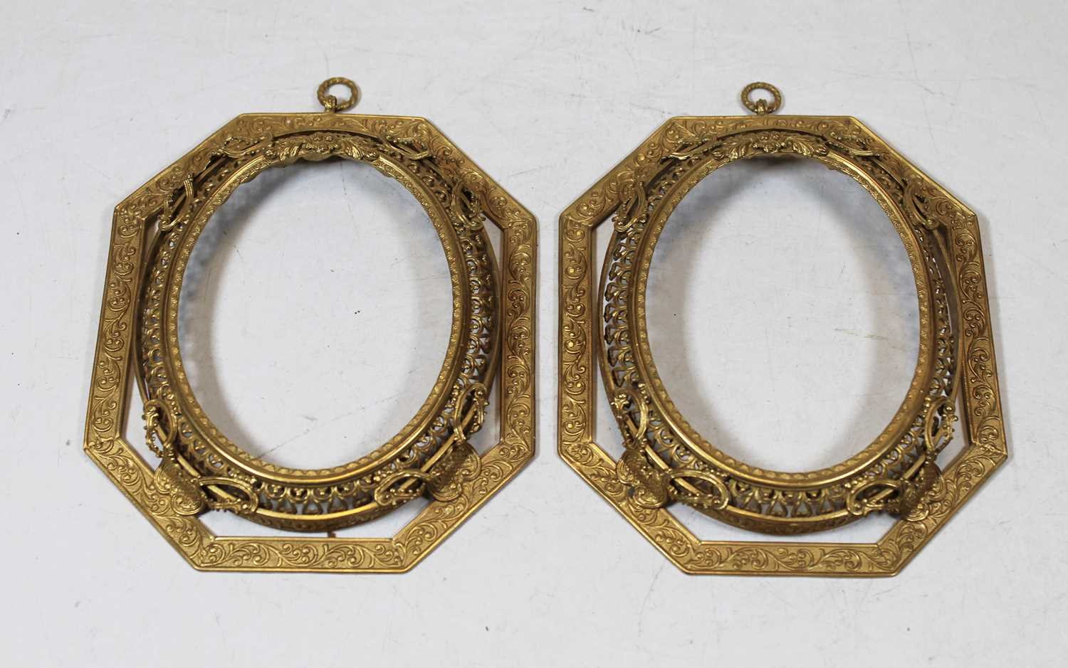 A pair of late 19th century gilt metal frames, each of octagonal form with scrolling floral