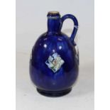 A Royal Doulton stoneware flagon, on a mottled blue ground with raised floral decoration and loop