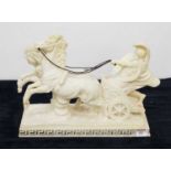 A resin figure of a Roman soldier in chariot with horses, on a Greek key moulded base, signed