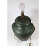 A modern green glazed table lamp of squat baluster form having green man mask handles with silk