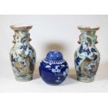 A pair of stoneware vases, each of baluster form, enamel decorated with various birds, butterflies
