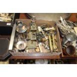 A box of miscellaneous metalware, to include pair of brass candlesticks, loose flatware, silver