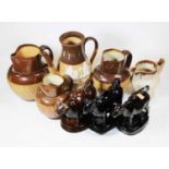 A 19th century Staffordshire brown glazed cow creamer; together with two black glazed examples;